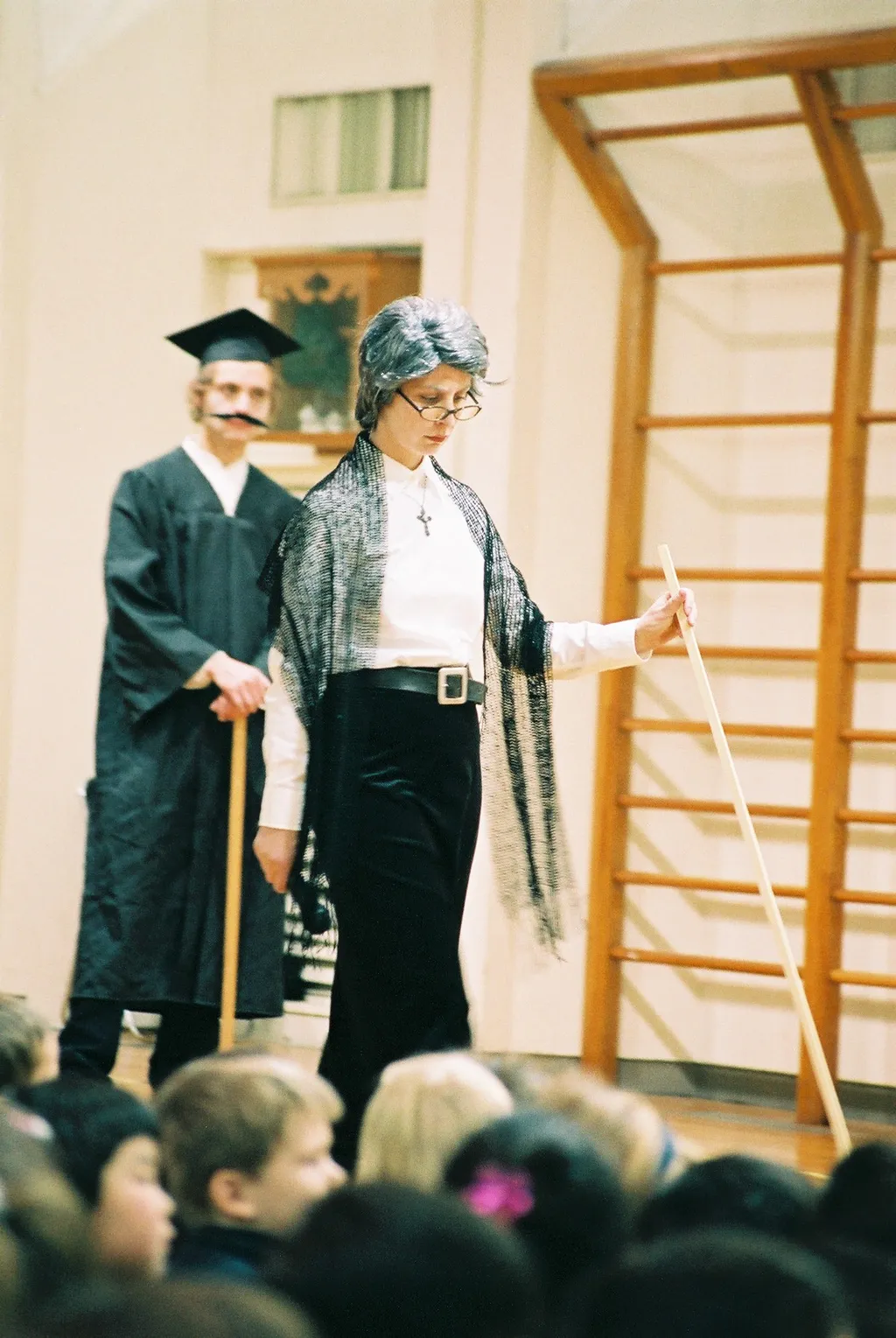 Donna and a colleague in Victorian-era costume in a school hall