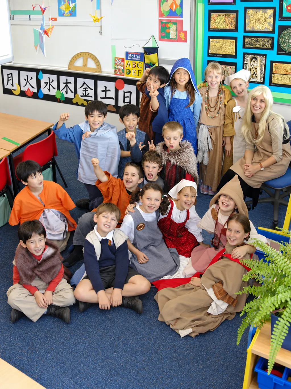 Donna with students in costume on a classroom carpet
